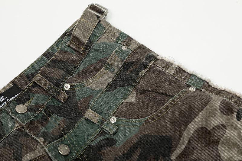 Close-up of the front waistband and pocket area on camo jeans with double-belt detail