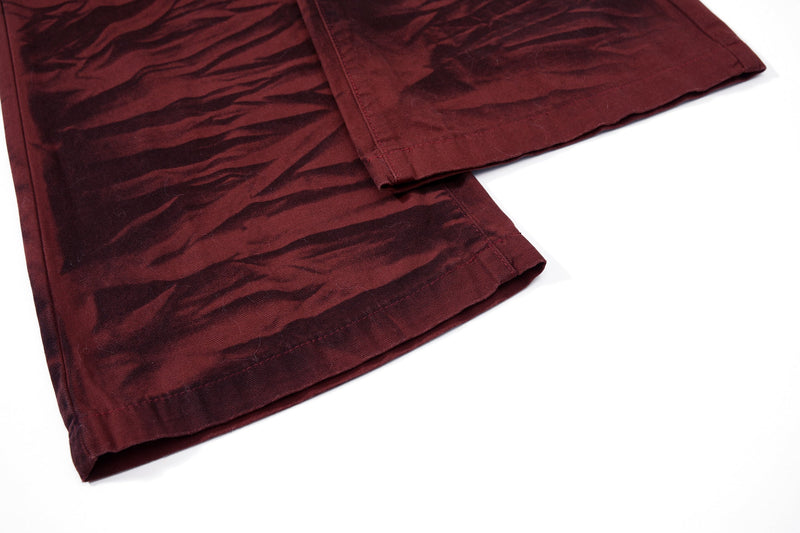 Close-up of the hem on burgundy tiger-print flared pants