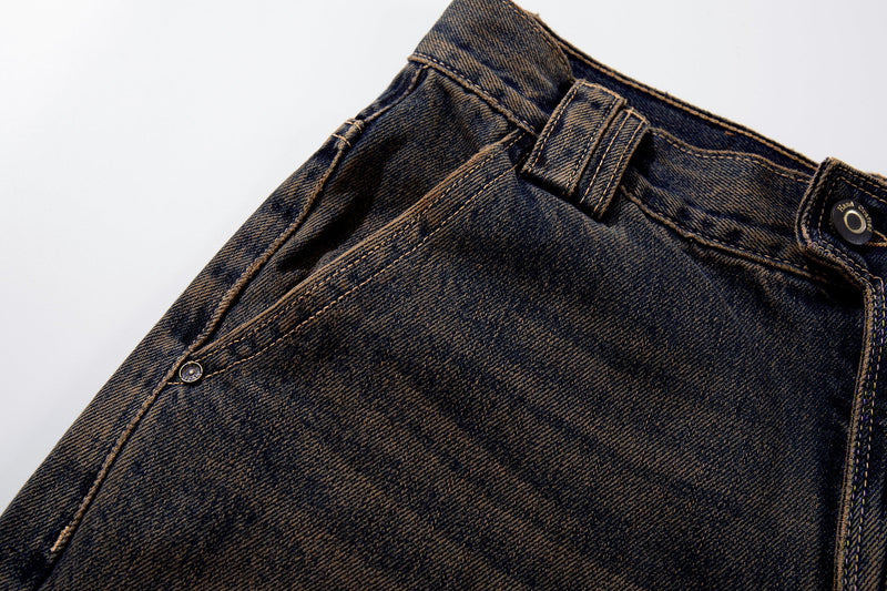 Close-up of the side waist on dark-wash jeans showing pocket seam and belt loop