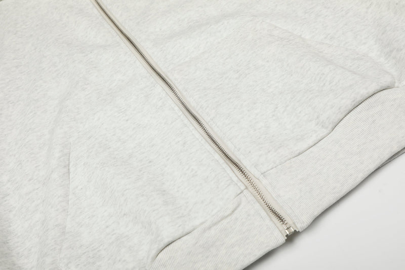 Close-up of light gray hoodie front zipper and pocket seam