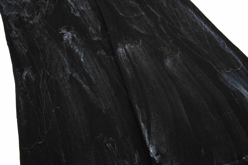 Close-up of black washed denim leg with subtle fading and seam lines
