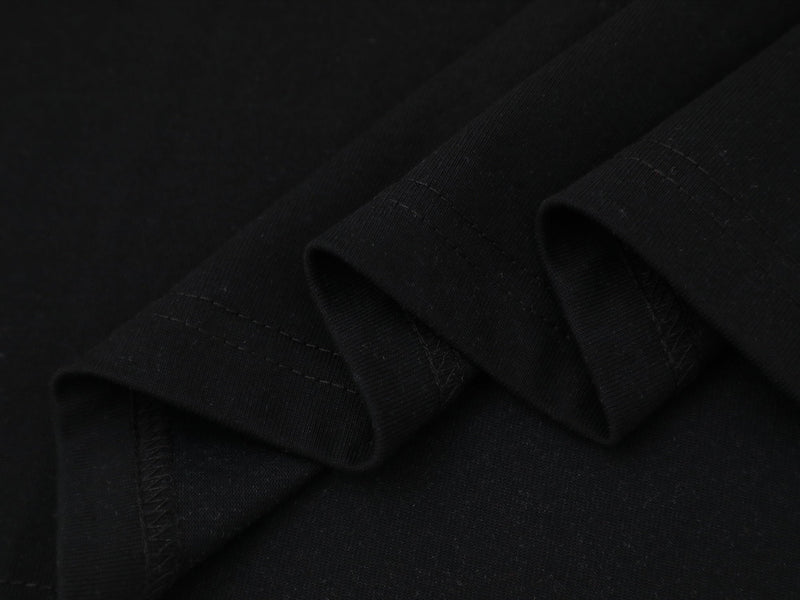 Close-up of black ribbed sleeve fabric and stitching on the tee