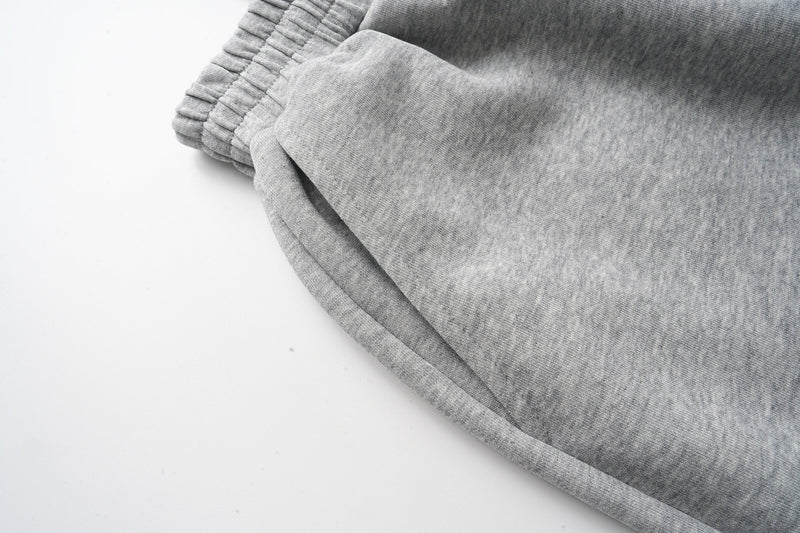 Close-up of gray sweat shorts leg opening and stitched hem