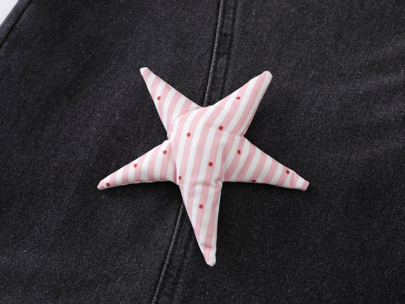 Close-up of pink striped star patch on black denim