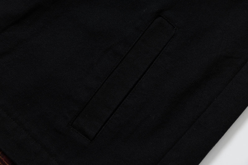 Close-up of black hoodie pocket seam on textured fabric