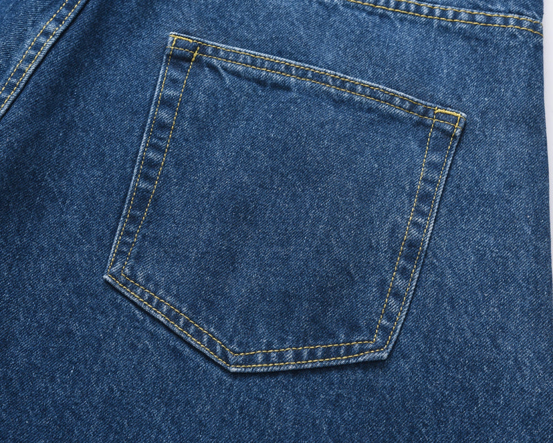 Close-up of blue denim back pocket with yellow stitching