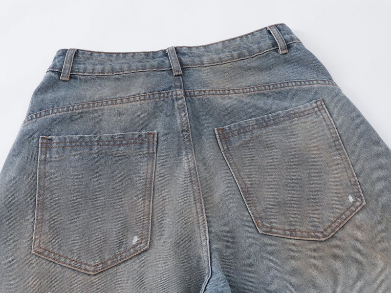 Close-up of the back waistband and patch pockets on faded blue jeans