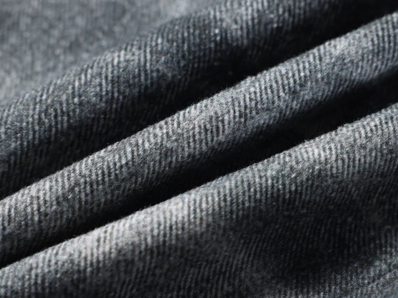 Close-up of washed black denim fabric with ribbed texture and soft folds