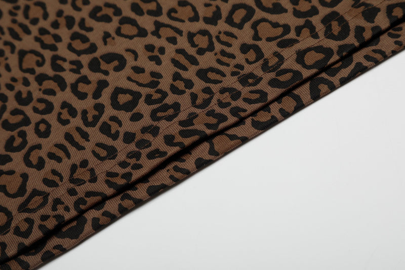 Close-up of brown leopard print polo tee fabric with black spots and visible hem stitching