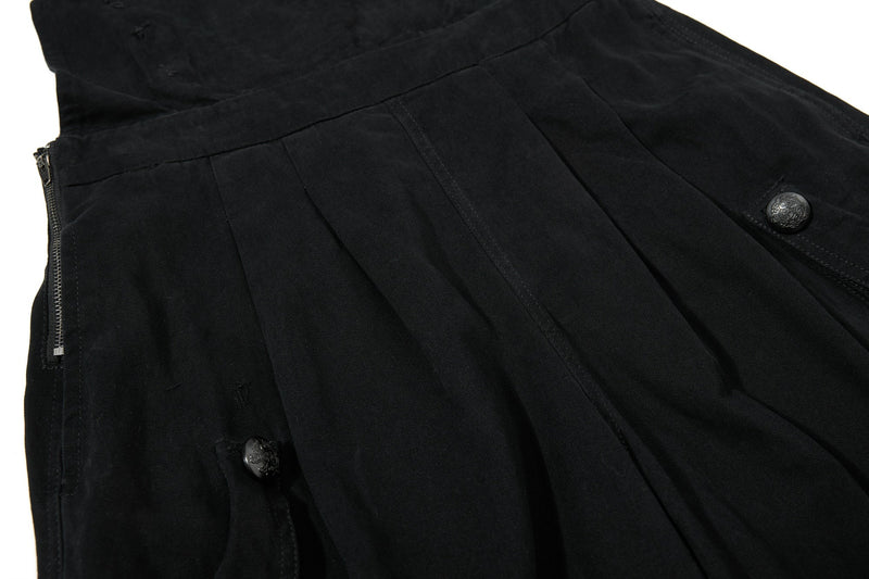 Close-up of black shorts pleated front with side zip pocket and buttoned cargo pocket
