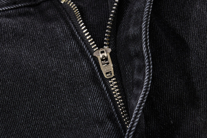 Close-up of metal zipper on black denim jeans