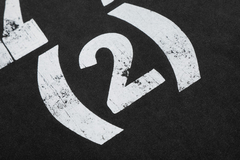 Close-up of a black vintage washed graphic tee with distressed white bold circular print and the number 24 design