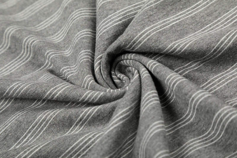Close-up of gray striped tee fabric folded into a swirl, showing soft knit texture