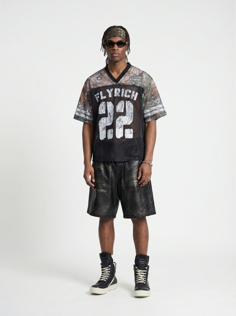 Model wearing a black camo mesh jersey T-shirt with Fly Rich 22 print, styled with shorts and high-top sneakers