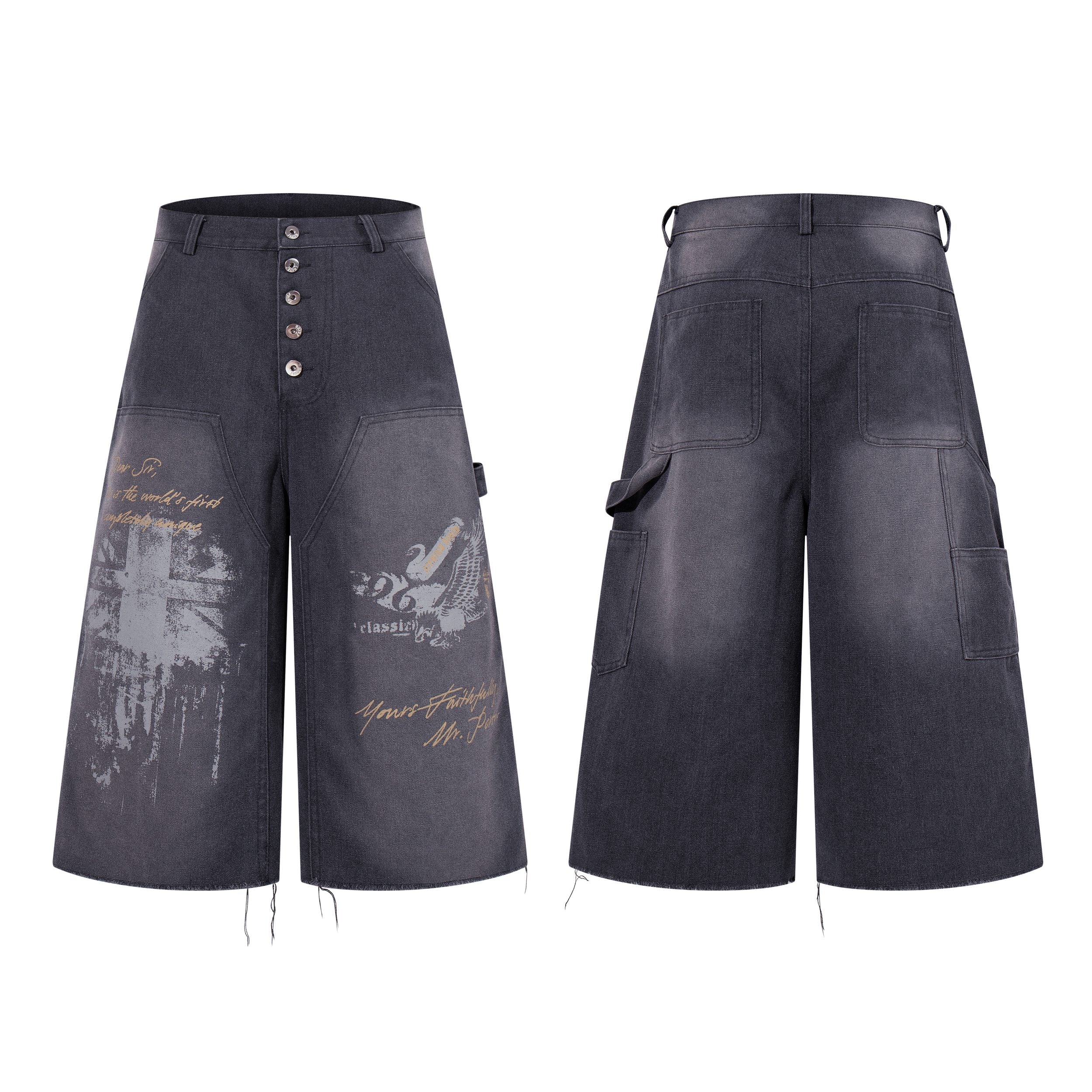Front and back view of wide-leg grey washed denim shorts with vintage cross and eagle graphic prints and button fly