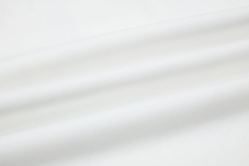 White polo tee with subtle textured fabric and clean folded drape, showcasing a minimalist medieval streetwear style