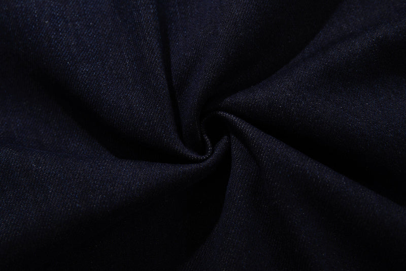 Close-up of deep indigo denim fabric with soft folds and visible weave texture