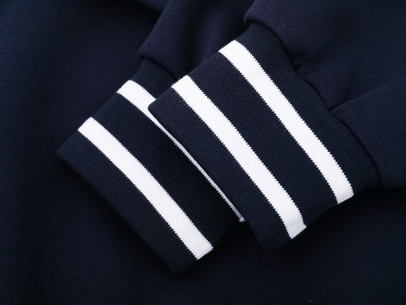 Close-up of navy sleeve cuff with two white varsity stripes