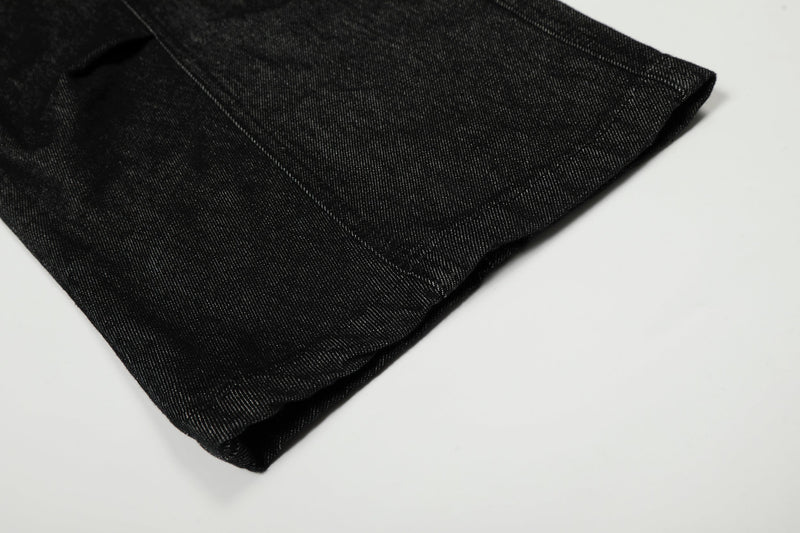 Close-up of black denim hem showing wide leg opening and stitched cuff