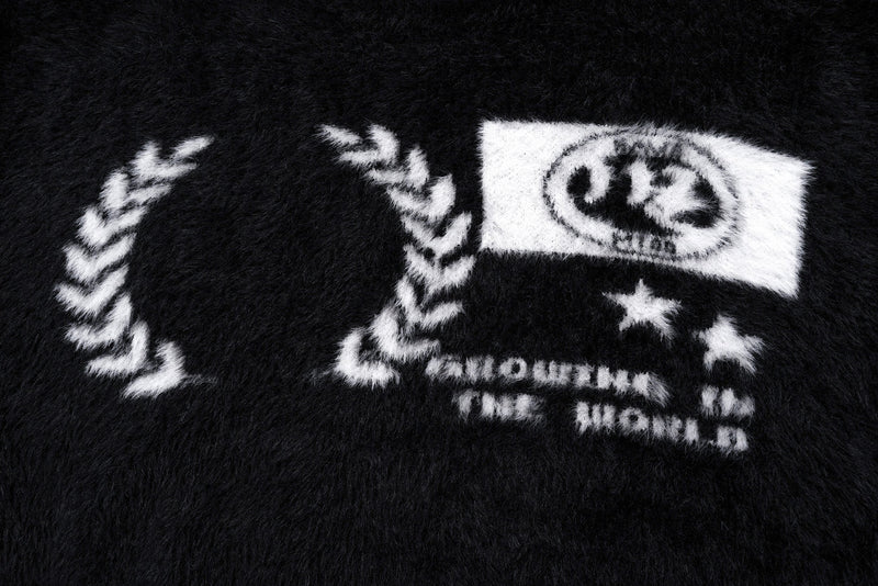 Close-up of the front graphic on the black fuzzy pullover sweater