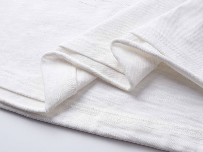 Close-up of white long sleeve tee sleeve cuffs and hem stitching