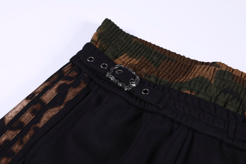 Angled close-up of the leopard waistband, black buckle strap, and metal eyelets