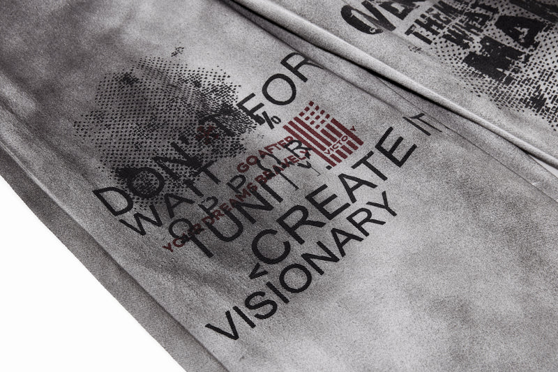 Close-up of front leg graphic text print on gray washed denim pants