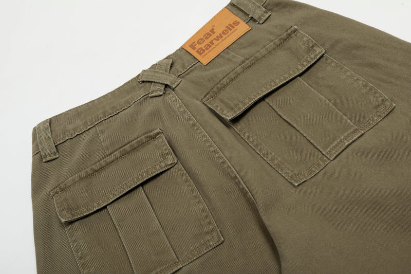 Close-up of back waistband and pockets on olive cargo jeans with leather brand patch