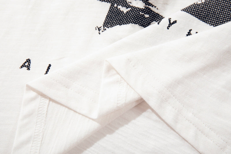 Close-up of a white graphic streetwear T-shirt with black punk-style print and folded sleeves