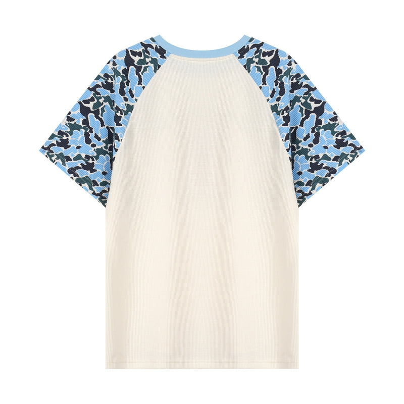 Cream raglan graphic T-shirt with blue camo sleeves and light blue trim on a white background