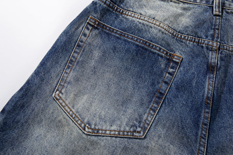 Back pocket close-up on blue denim jeans with heavy faded wash