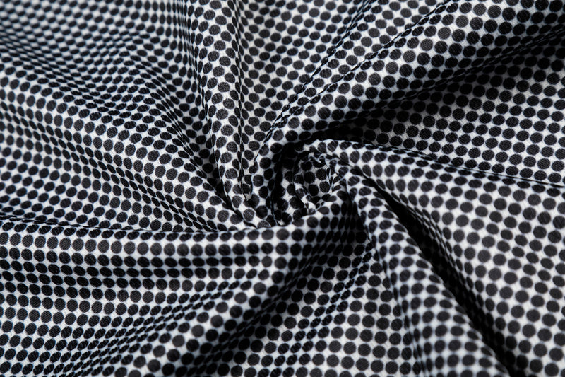 Black and white polka dot mesh jersey fabric with gathered folds and streetwear-inspired texture