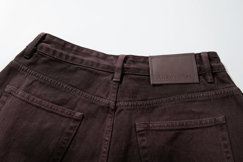 Close-up of back waistband with brown leather brand patch and belt loops