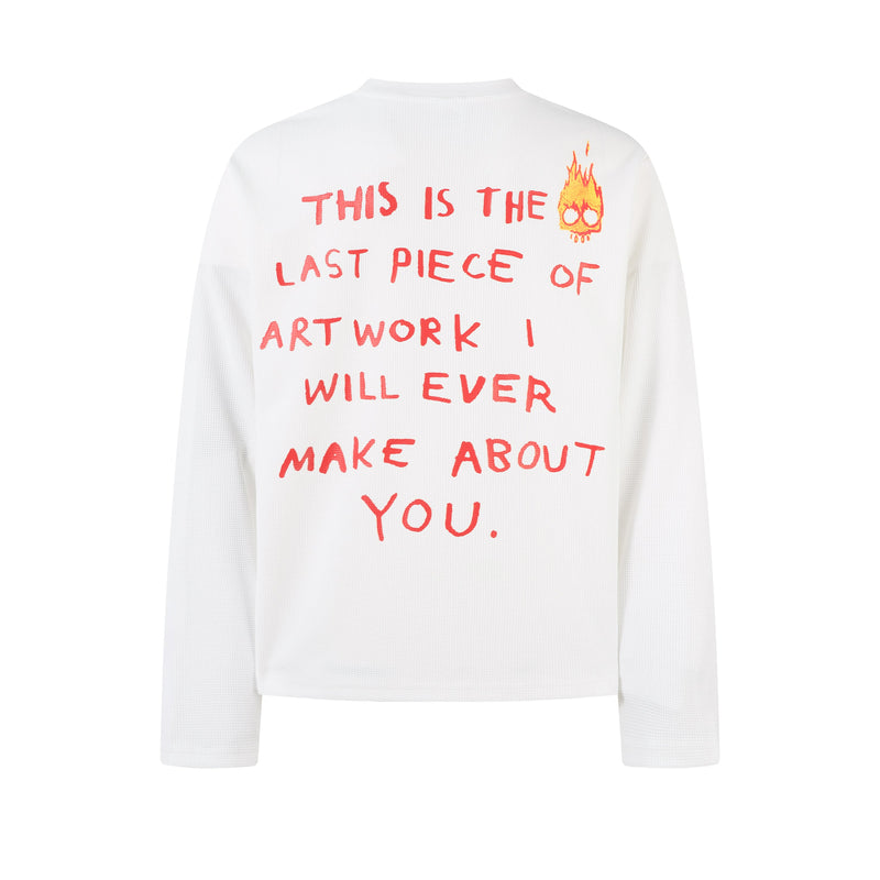 Back of white long sleeve tee with red text and small flame doodle at upper right