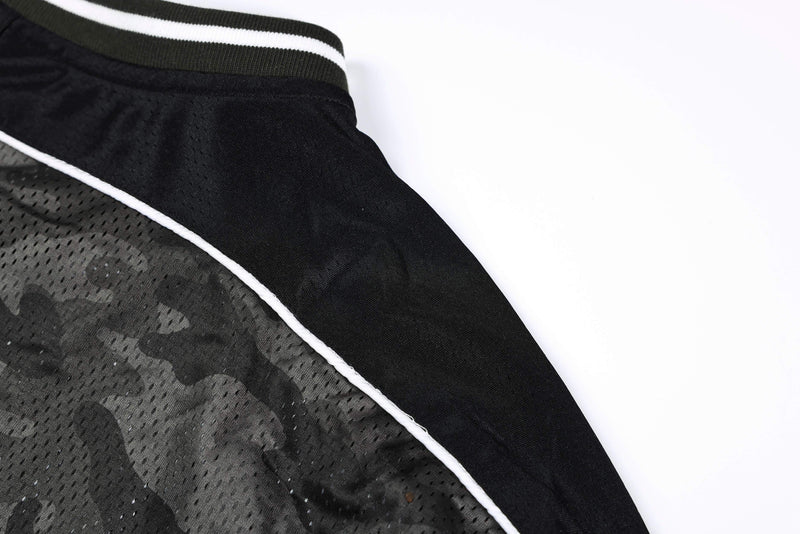 Close-up of a dark camo mesh athletic jersey with white piping and ribbed black-and-white trim