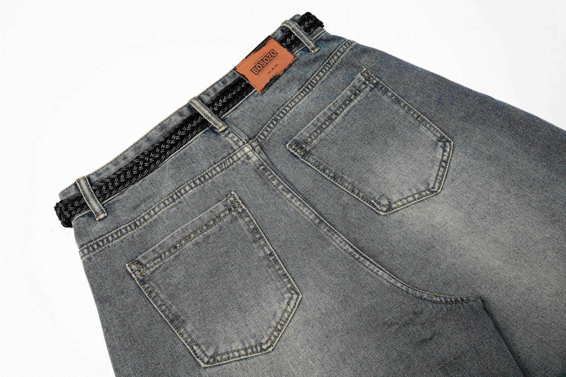 Close-up of blue jeans back pockets and braided black waist trim