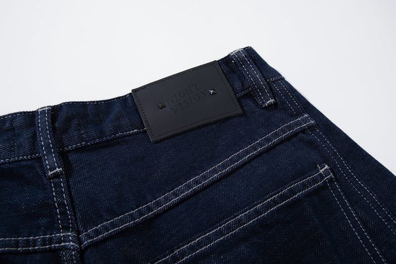 Close-up of the waistband with dark leather logo patch and belt loops