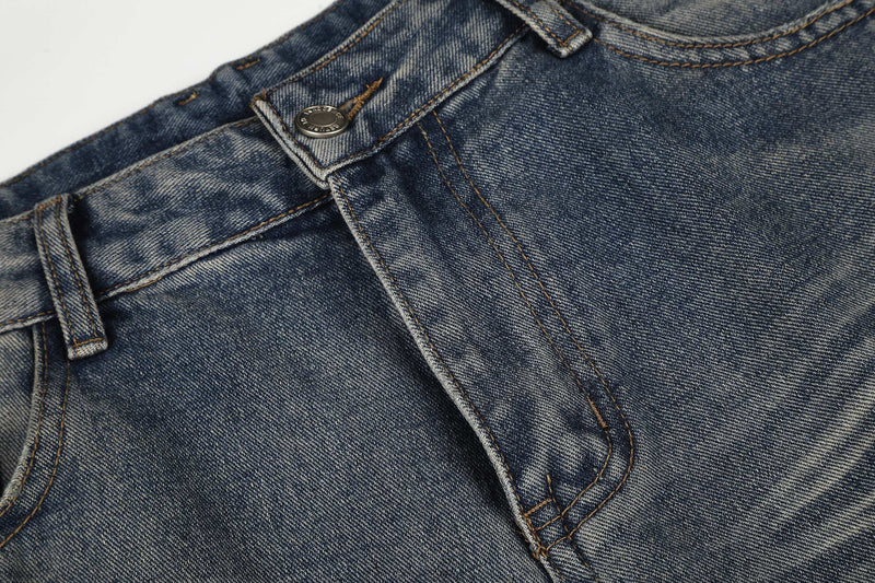 Close-up of the waistband and top button on faded blue denim jeans