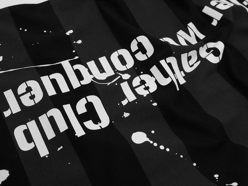 Black oversized graphic tee with bold white distressed lettering and vertical stripe pattern, Y2K streetwear style