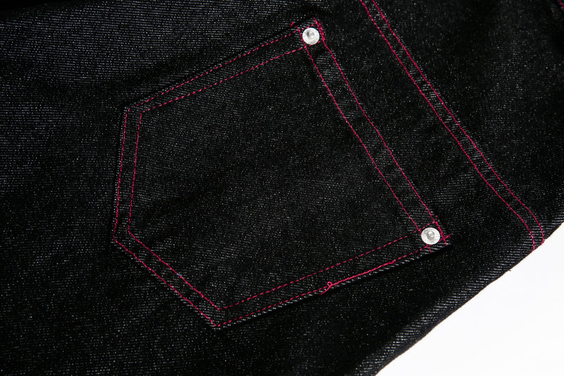 Close-up of back pocket on black wide leg jeans with red stitching
