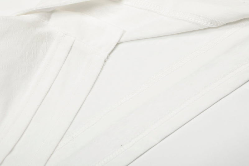 Close-up of white tee sleeve seam and stitched construction detail