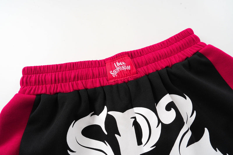 Close-up of magenta waistband and SP2 logo label on black shorts