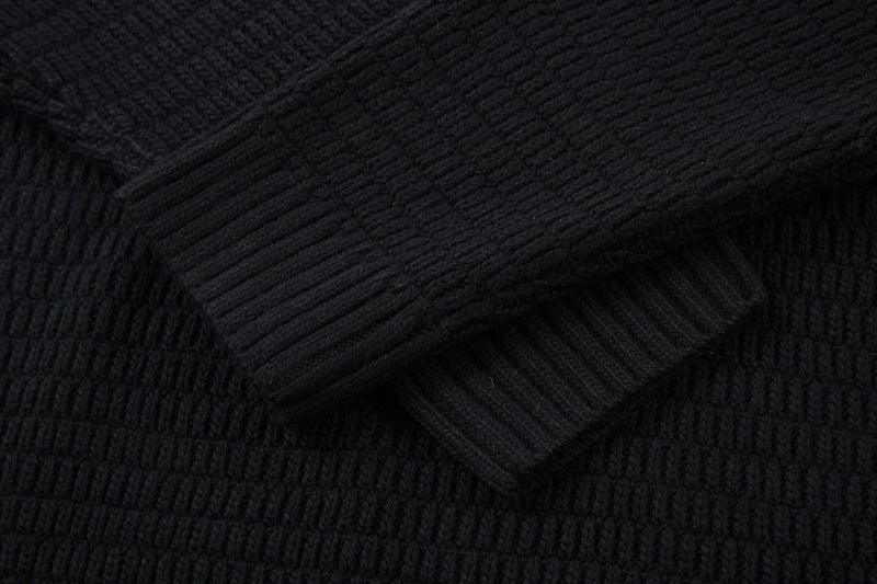 Close-up of black knit cuff and sleeve hem with ribbed pattern