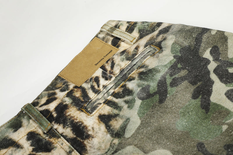 Back pocket close-up on leopard camo cargo shorts with tan patch label and welt pocket