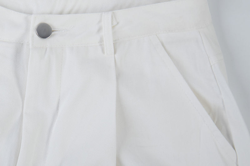 Close-up of white cargo pants waist with silver snap button and twill texture