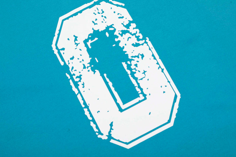 Turquoise varsity t-shirt with a distressed white number patch graphic on the chest