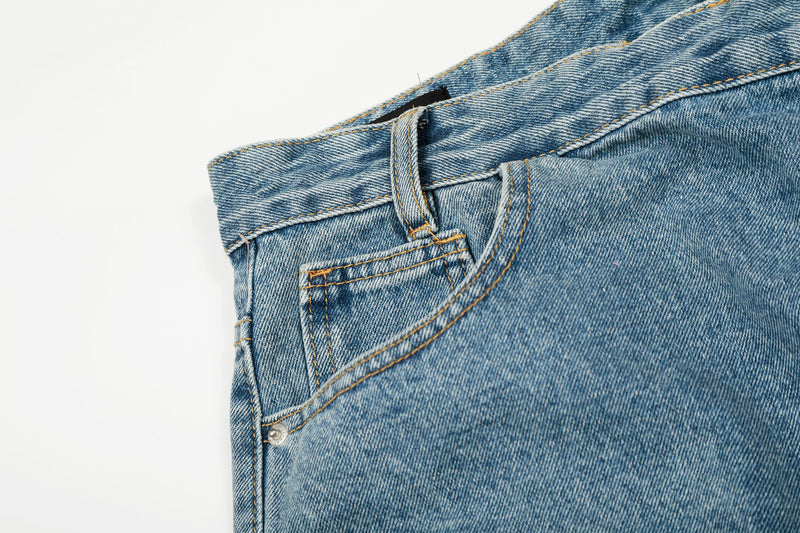 Close-up of front pocket and waistband on blue wide-leg denim jeans