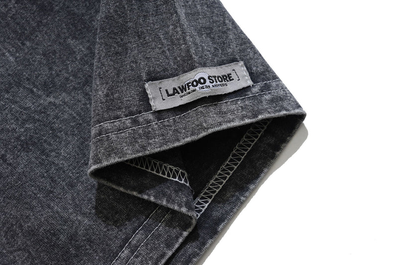 Vintage washed black graphic tee sleeve with visible LAWFOO STORE hem label and contrast stitching