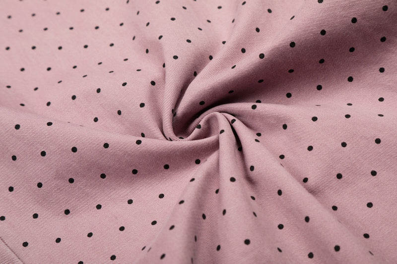 Close-up of pink polka dot fabric with a gathered fold