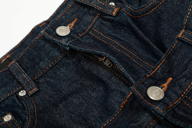 Close-up of the front waist and zipper opening on deep indigo jeans with double-waist construction